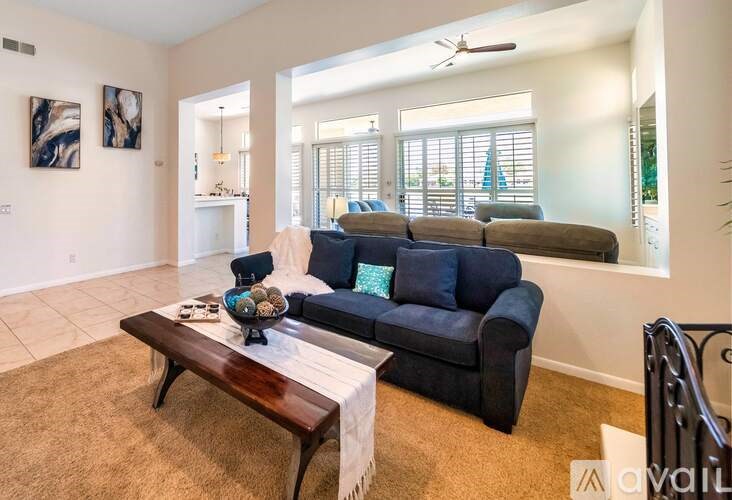 A living room with a dark blue couch and a wooden coffee table.