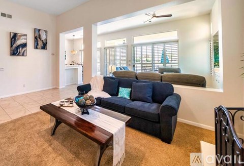 A living room with a dark blue couch and a wooden coffee table.
