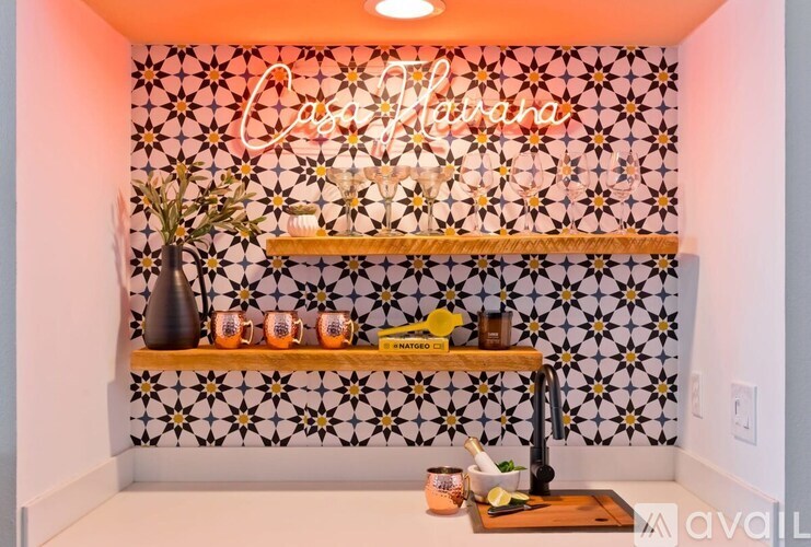 A wall with a black and white pattern and a shelf with a vase and candles.