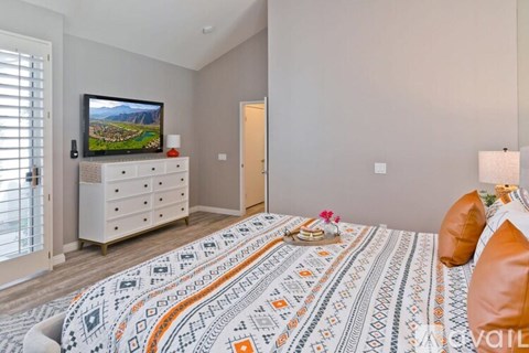 A bedroom with a large bed and a television on a cabinet.