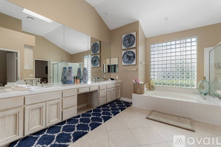 A bathroom with a large tub and a vanity with a mirror.