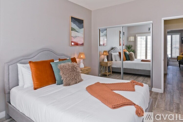 A bedroom with a large bed and a painting on the wall.