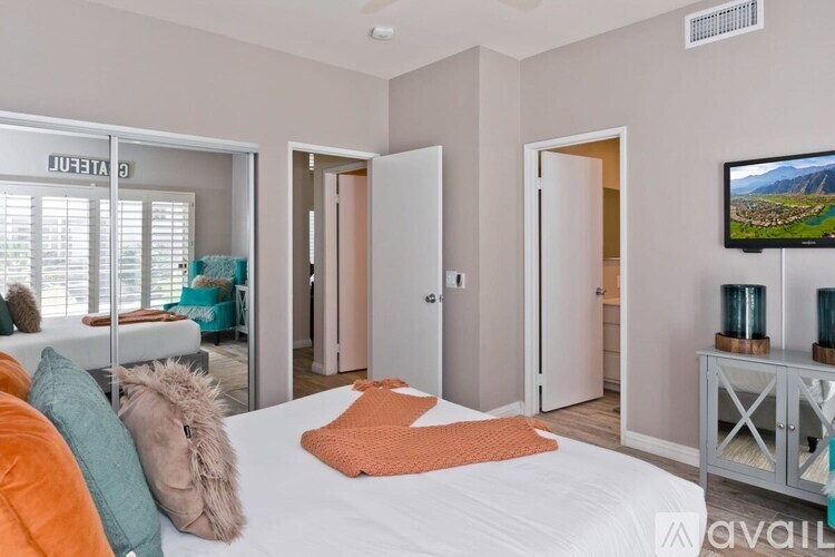 A bedroom with a bed, a couch, and a television.