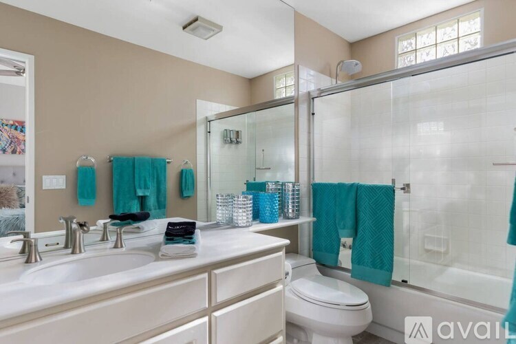 A bathroom with a white toilet, a sink with a silver faucet, and a glass shower door.