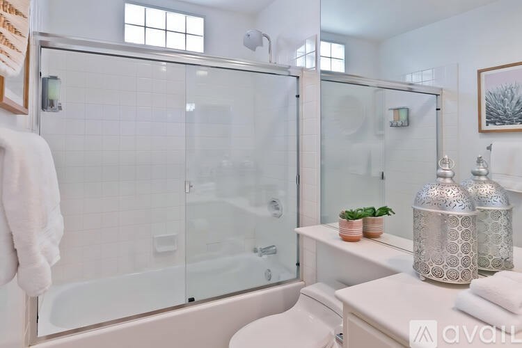 A bathroom with a glass shower door and a white towel hanging on the wall.