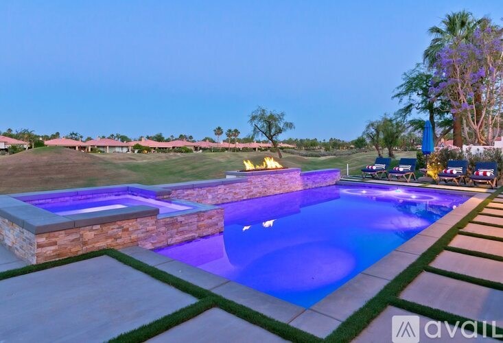 A swimming pool with a stone border and a stone wall.
