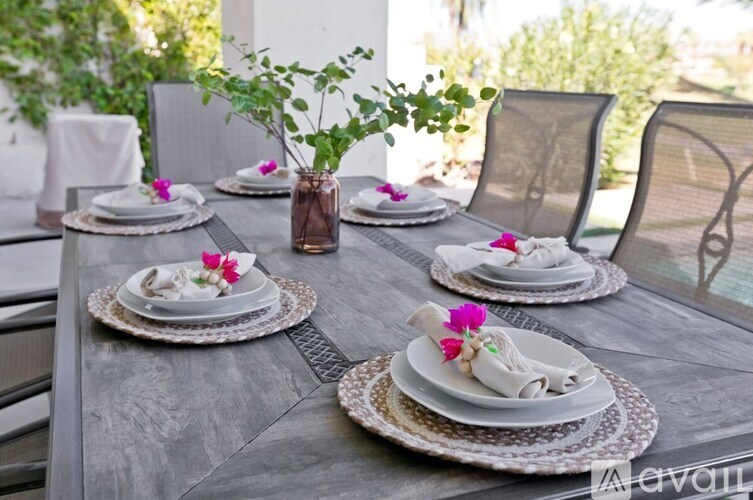 A table set for a meal with a vase of flowers in the center.