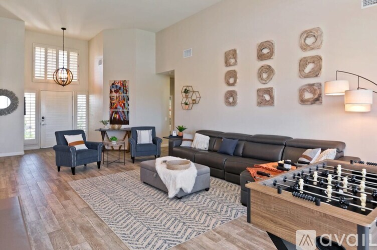 A living room with a foosball table in the middle.