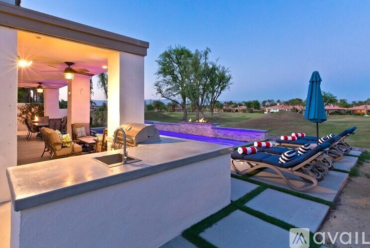 A modern house with a pool and lounge chairs.