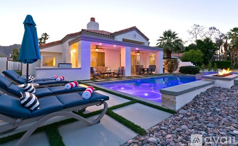 A house with a pool and lounge chairs.