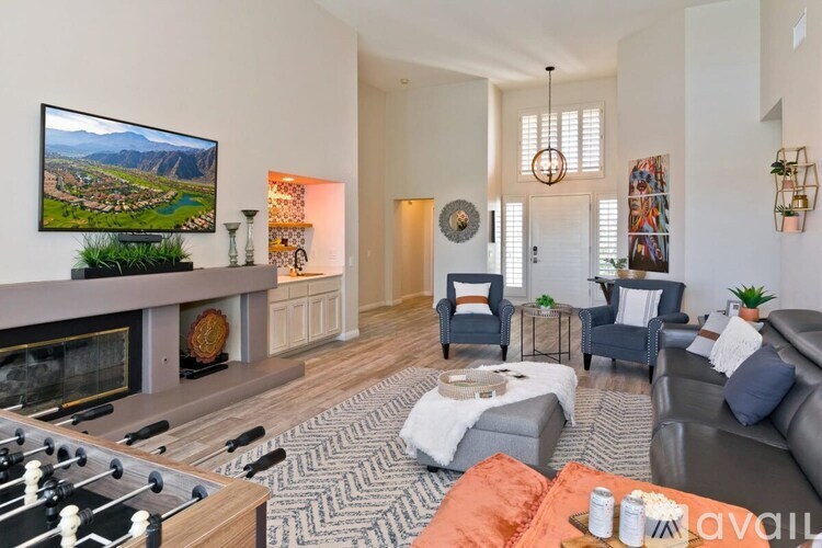 A living room with a foosball table and a fireplace.
