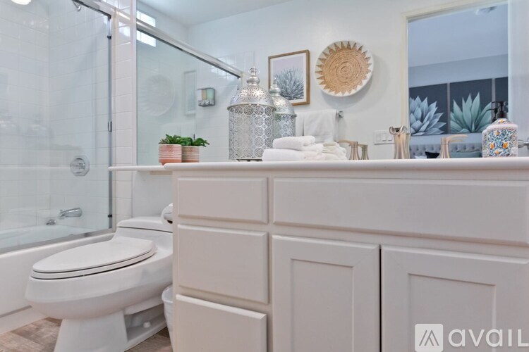 A white bathroom with a toilet, sink, and shower.