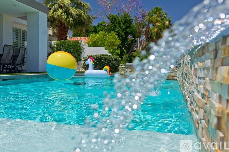A pool with a yellow ball and a unicorn float.