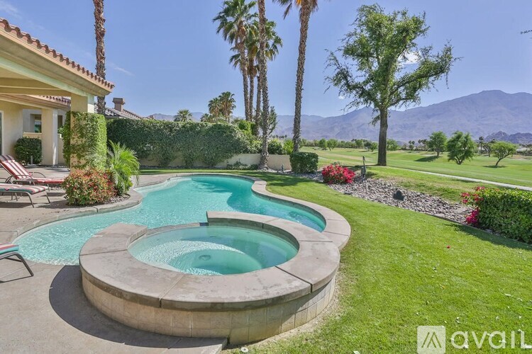 A house with a pool and palm trees in the background.