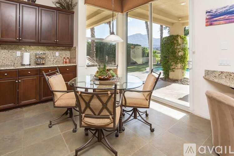 A kitchen with brown chairs and a glass table.