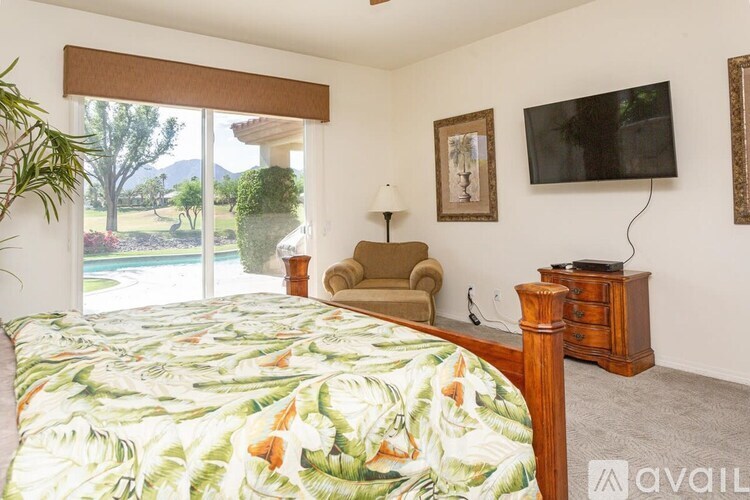 A bedroom with a large bed and a chair.