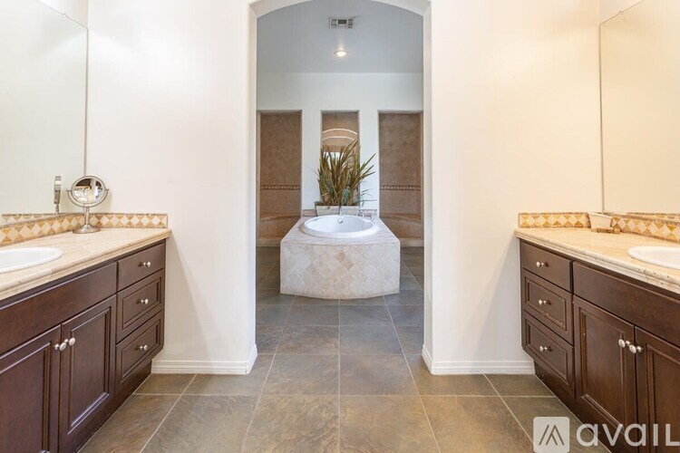 A bathroom with a large mirror, a sink, and a bathtub.