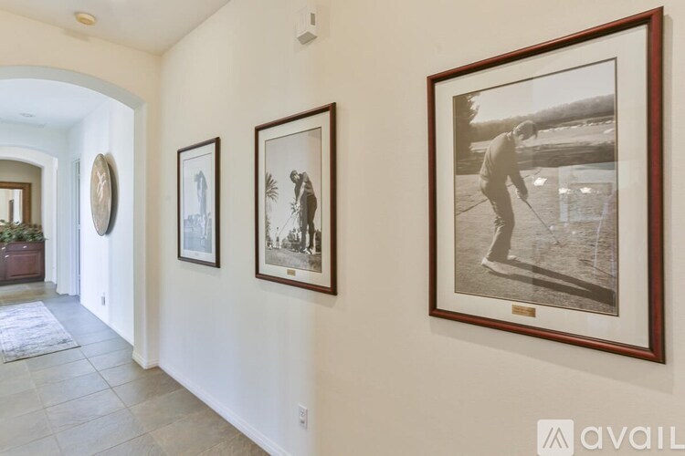 Three framed pictures hang on a wall in a hallway.
