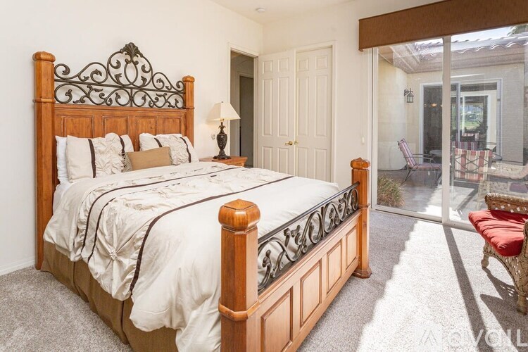 A bed with a wooden headboard and footboard with a white comforter and pillows.