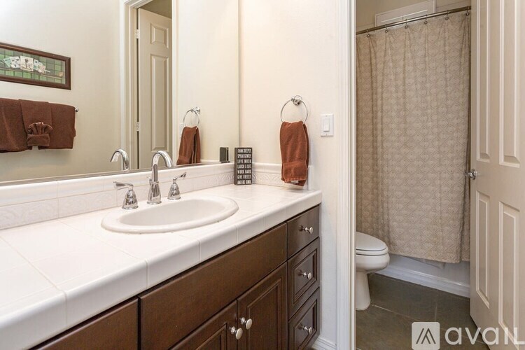 A bathroom with a white sink and brown towels.