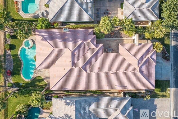 A bird's eye view of a residential area with houses and a swimming pool.