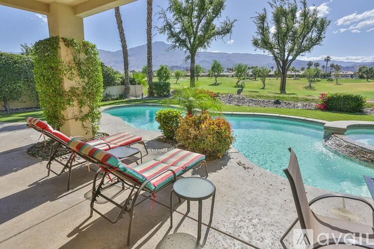 A poolside table and chairs are set up on a patio.