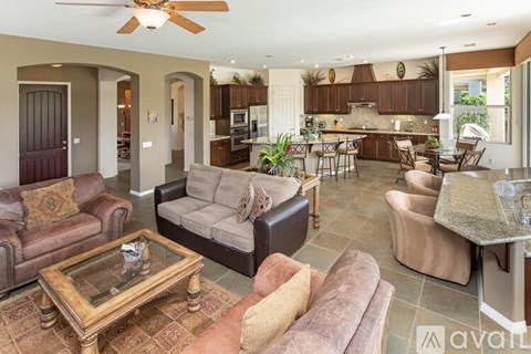 A living room with a brown couch and a glass coffee table.