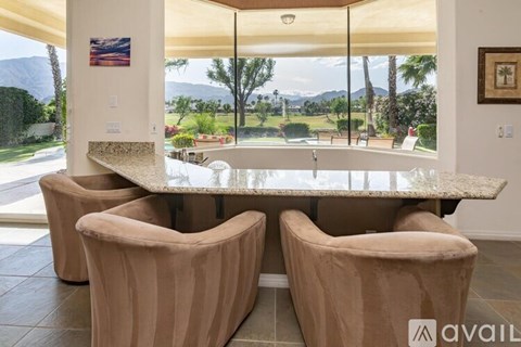 A dining room with a table and chairs and a mountain view.