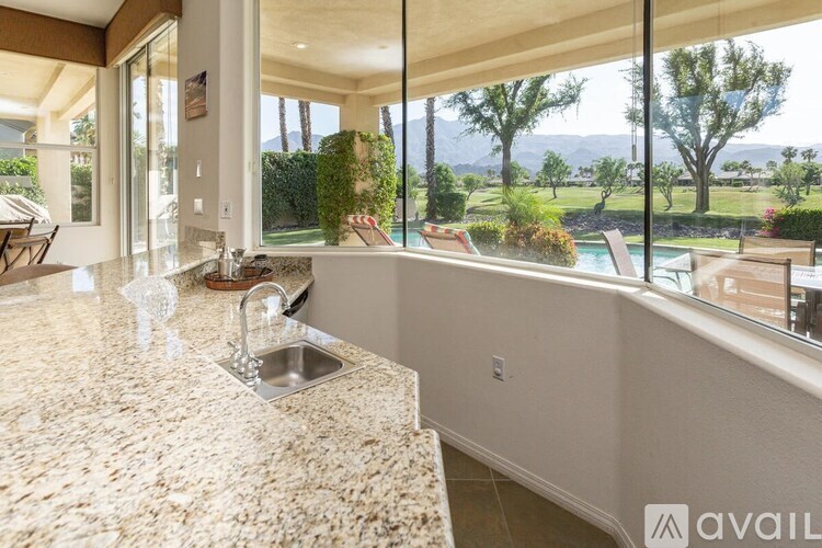 A kitchen with granite countertops and a view of the outdoors.