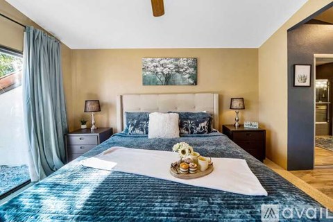 A bedroom with a large bed and a ceiling fan.