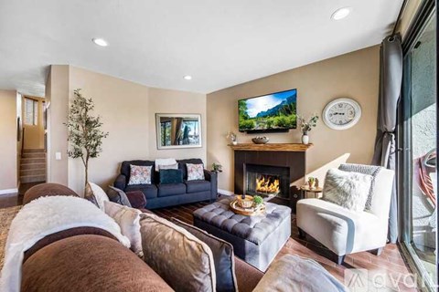 A living room with a fireplace and a television on the wall.