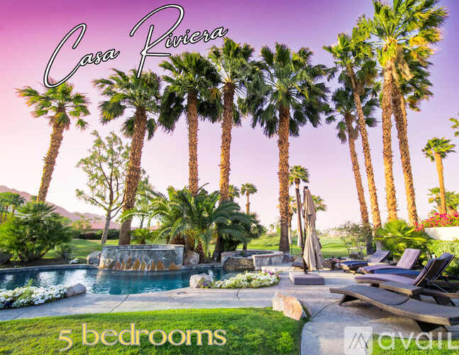 A pool surrounded by palm trees and a sign that says "Casa Riviera".
