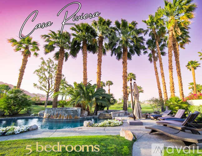 A pool surrounded by palm trees and a sign that says "Casa Riviera".