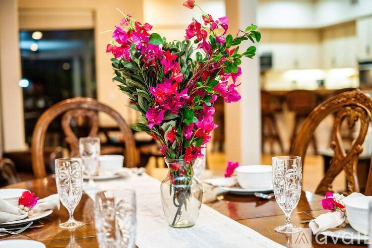 A heart-shaped arrangement of pink flowers sits in a vase on a table.