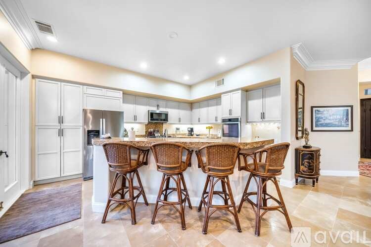 A kitchen with a bar area and chairs.