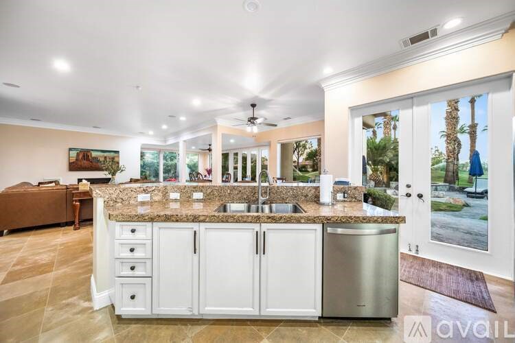 A kitchen with a granite countertop and stainless steel appliances.
