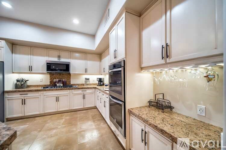 A kitchen with a granite countertop and a refrigerator.