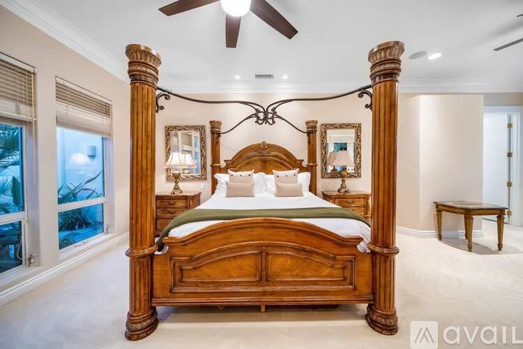 A bedroom with a large bed and a ceiling fan.