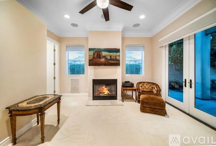 A living room with a fireplace and a painting on the wall.