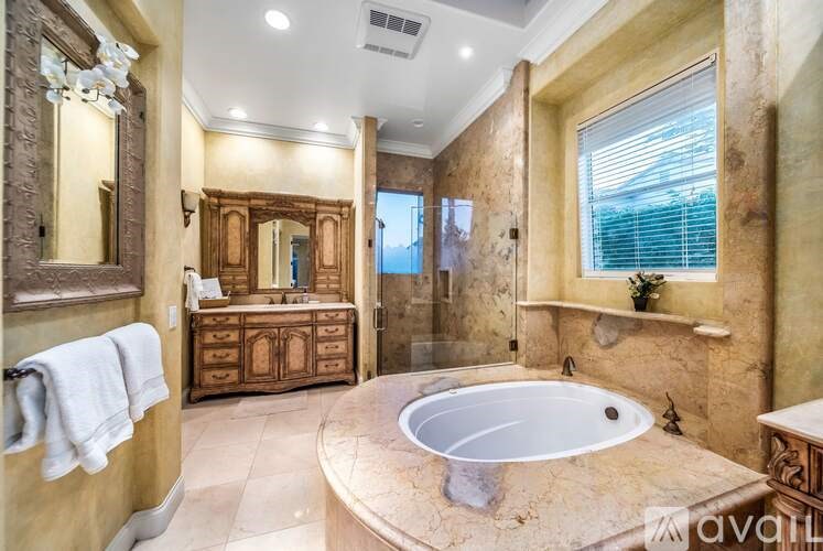 A large, luxurious bathroom with a round tub and a large mirror.