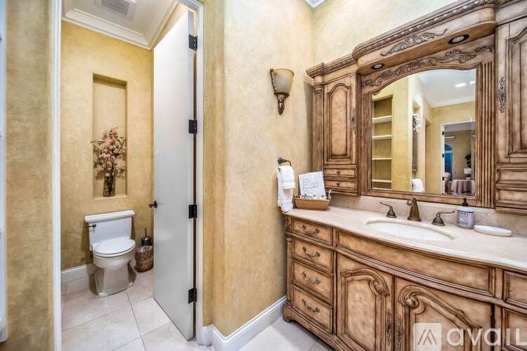 A bathroom with a toilet, sink, and mirror.