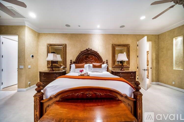 A bedroom with a large bed and a ceiling fan.