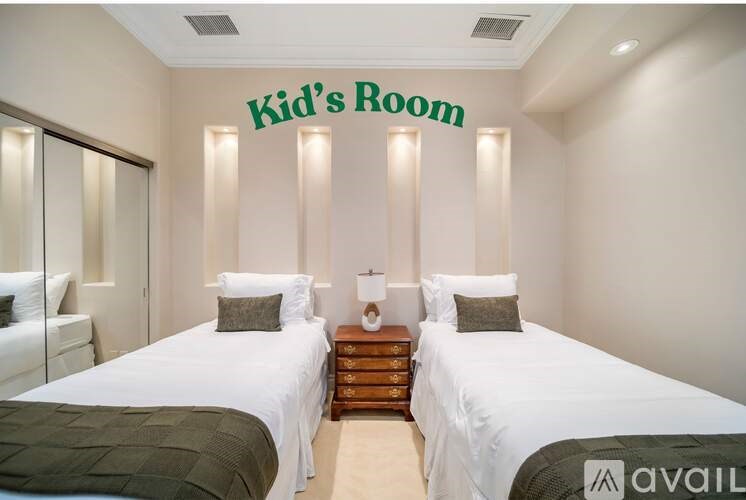 A bedroom with two beds and a sign that says "Kid's Room".