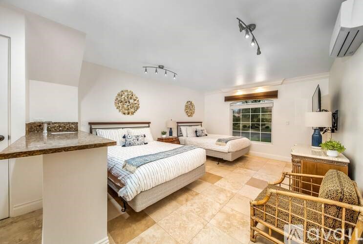 A bedroom with a bed, a couch, and a chair.