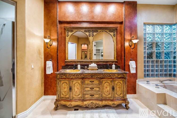 A bathroom with a wooden vanity and a mirror above it.