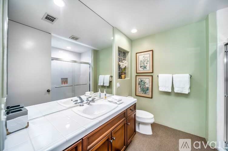 A bathroom with a white countertop and a toilet in the corner.