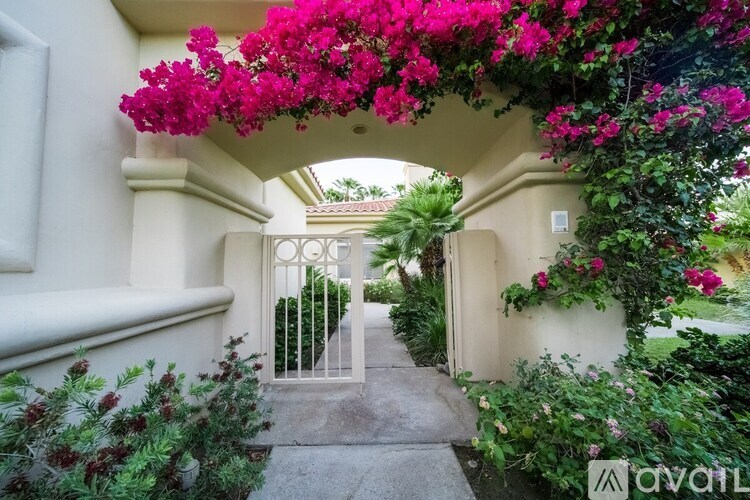 A pathway leads to a gate with a white archway above it.