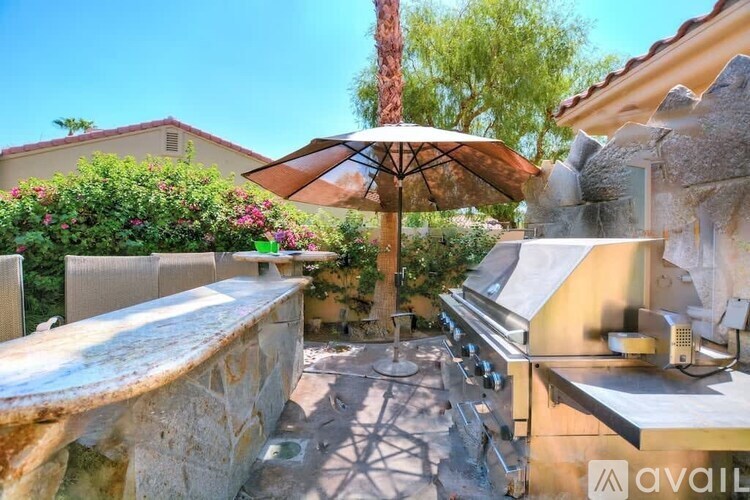 A patio with a table and chairs under an umbrella.