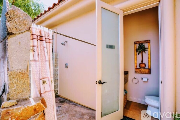 A bathroom with a toilet, sink, and shower area.