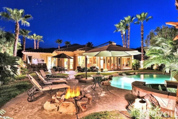 A house with a pool and a fire pit in the backyard.